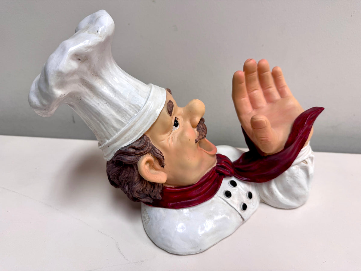 Figura de chef sujetando una botella de vino